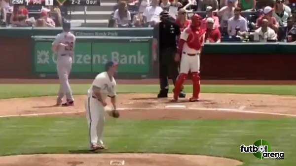 Kucağında bebek ile topu yakalayan süper baba